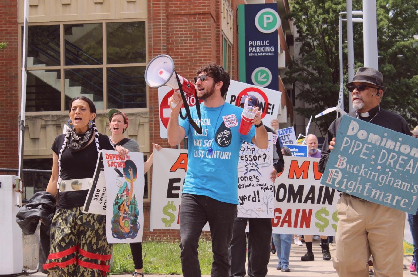 Person holding a megaphone at an event for the Climate and Clean Energy Equity Fund